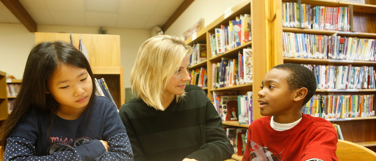 A speech language pathologist working with two children.
