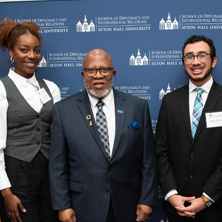 Photo of His Excellency Mr. Dennis Francis, President of the 78th Session of the United Nations General Assembly with two diplomacy students 