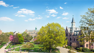 Image of President's Hall and the campus green during summer. 