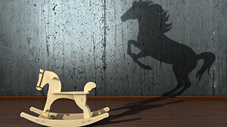 A rocking horse with the shadow of a stallion representing hidden potential.