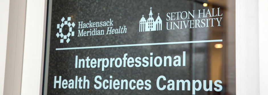 IHS Door sign with the Hackensack Meridian Health and the Seton Hall logos above the words "Interprofessional Health Sciences Campus."