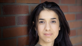 Nadia Murad in front of a brick wall. 
