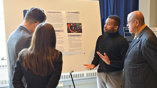 A photo of the Petersheim poster event.Professors Sulie Lin Chang and Jose L. LopezRev. Pritchett watching a poster presentation.