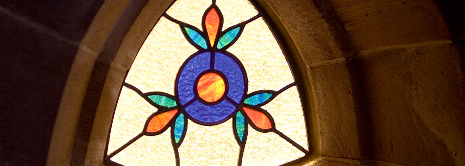 Stained glass window with sun shining through.