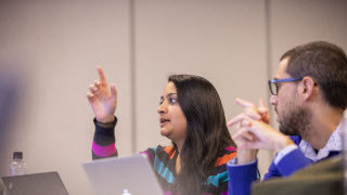 Students sitting in class, talking and discussing topics