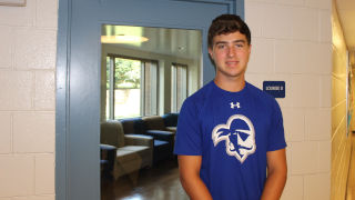 Andrew Luehrs standing in front of a SHU building lounge