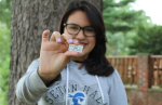 1856society Student holding an 1856 society pin.