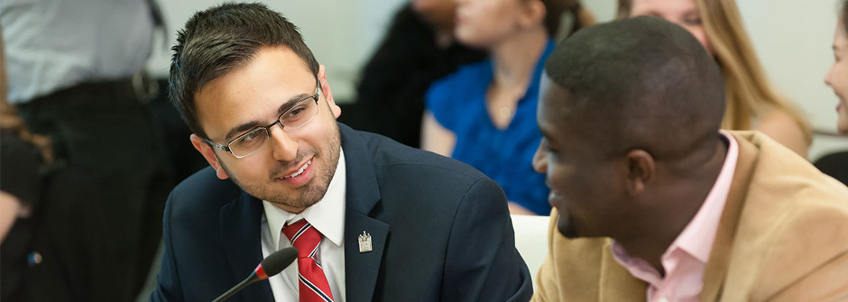 Diplomacy students speaking into a microphone during a panel discussion. 