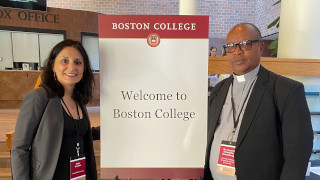 a photo of the provost with a guest in front of a poster