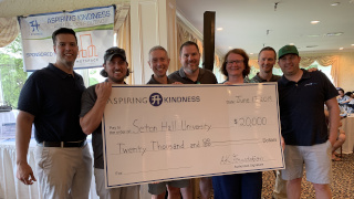 Members of the Aspiring Kindness Foundation holding a check. 
