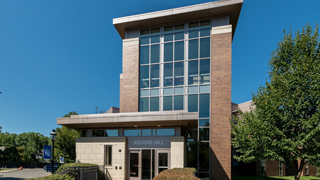 Image of the outside of Aquinas Hall in the summer. 