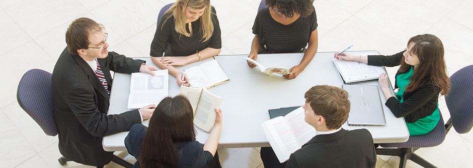 Custom Business Executive Programs Header - Professionals Sitting Around a Conference Room Table