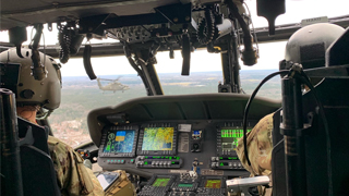 Cadet Bragg sitting in the Army Apache Helicopter