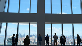 Photo of students looking out the sky lobby at Sloane &amp; Company, a Career Center site visit of the New York-based PR firm located in the World Trade Center.