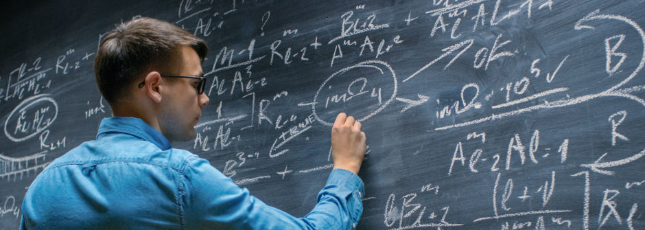 Man wearing glasses drawing on a chalkboard