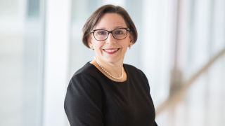 Dr. Greenberg smiling in black blouse