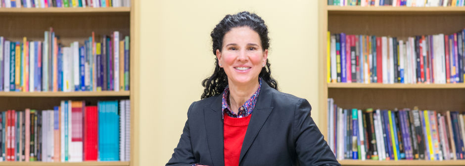 Photo of a woman by two bookshelves
