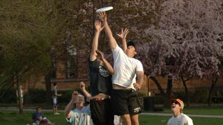 Blicks spelling out Students throwing frisby on the green