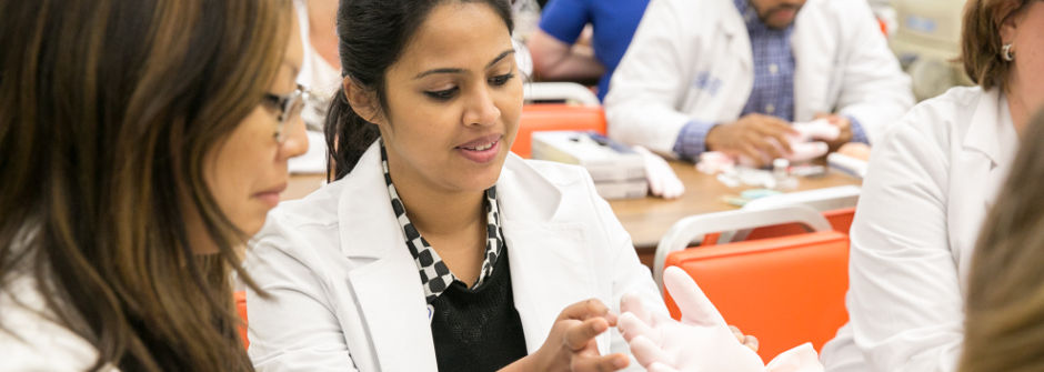 Nursing students putting on gloves.