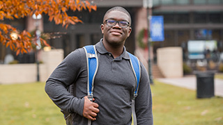 A person standing in front of the new University Center.