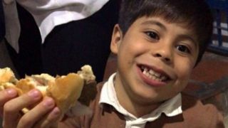 A child in Venezuela smiling for a picture taken by a scholar from the Latino Institute