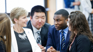 A group of leadership students in business attire with a female faculty member. 