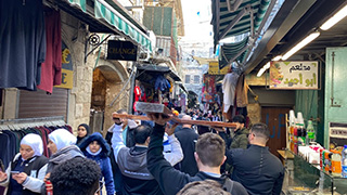 Group of people carrying a wooden cross