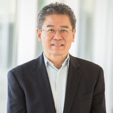 Leo Cheung wearing black blazer, smiling