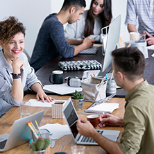 Group of people doing work at a desk.