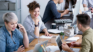 Group of people doing work at a desk.