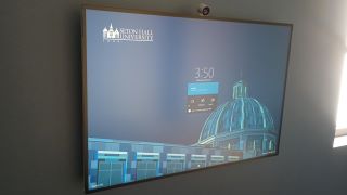 Wall-mounted MS Surface Hub 2S with a Seton Hall branded display.