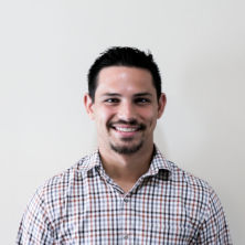 Headshot of Manny Sanchez wearing a checkered shirt