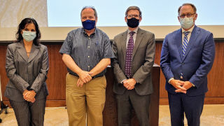 Martin Edward standing with President Nyre and other faculty members