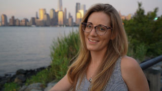 Headshot of Meg Reilly with the New York City skyline in the background