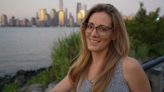 A man and a woman driving a boat on rough watersHeadshot of Meg Reilly with the New York City skyline in the background