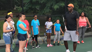 Players cover the tennis court in Branch Brook Park for the Greater Newark Tennis and Education Program, with Seton Hall education students assisting. Seton Hall education students in front of Althea Gibson's statue in Branch Brook Park in Newark.Students in the program gather for instruction. Retired tennis professional and Director of Tennis for GNTE, Bob Bynum with players during one of the summer sessions. 