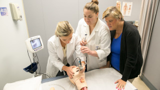 Nurse staring at a monitorNursing students work on a mannequin 