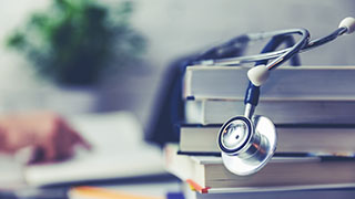 A Stethoscope Draped Over A Stack of Books