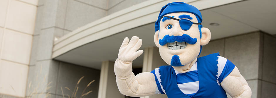 Seton Hall Pirate mascot waving hi in front of the IHS campus.