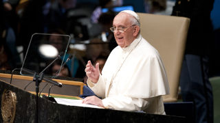 Photo of Pope Francis standing at a podium