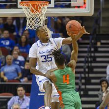 Romaro Gill on a basketball court blocking a shot