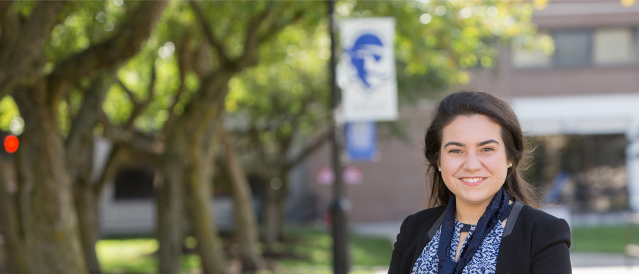 Image of a professional looking woman standing outside on the Seton Hall campus. 