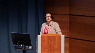 Kathleen Neville, Ph.D., R.N., FAAN, presenting her research at a podium 