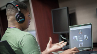 Young person at a computer using Soliya. 