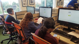 Students sitting at computers for sports polling