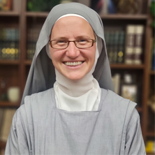 Headshot of Sr. Anne in a library. 