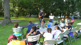 Tennis2_320 Pattric Davis teaching a large group of children outside