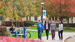 Students talking while they walk across campus.
