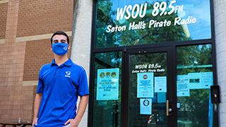 WSOU student with mask in front of radio station