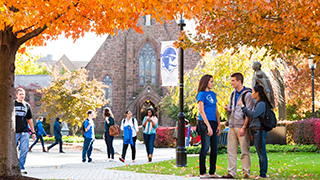 Students walking and talking on campus during a Fall day.